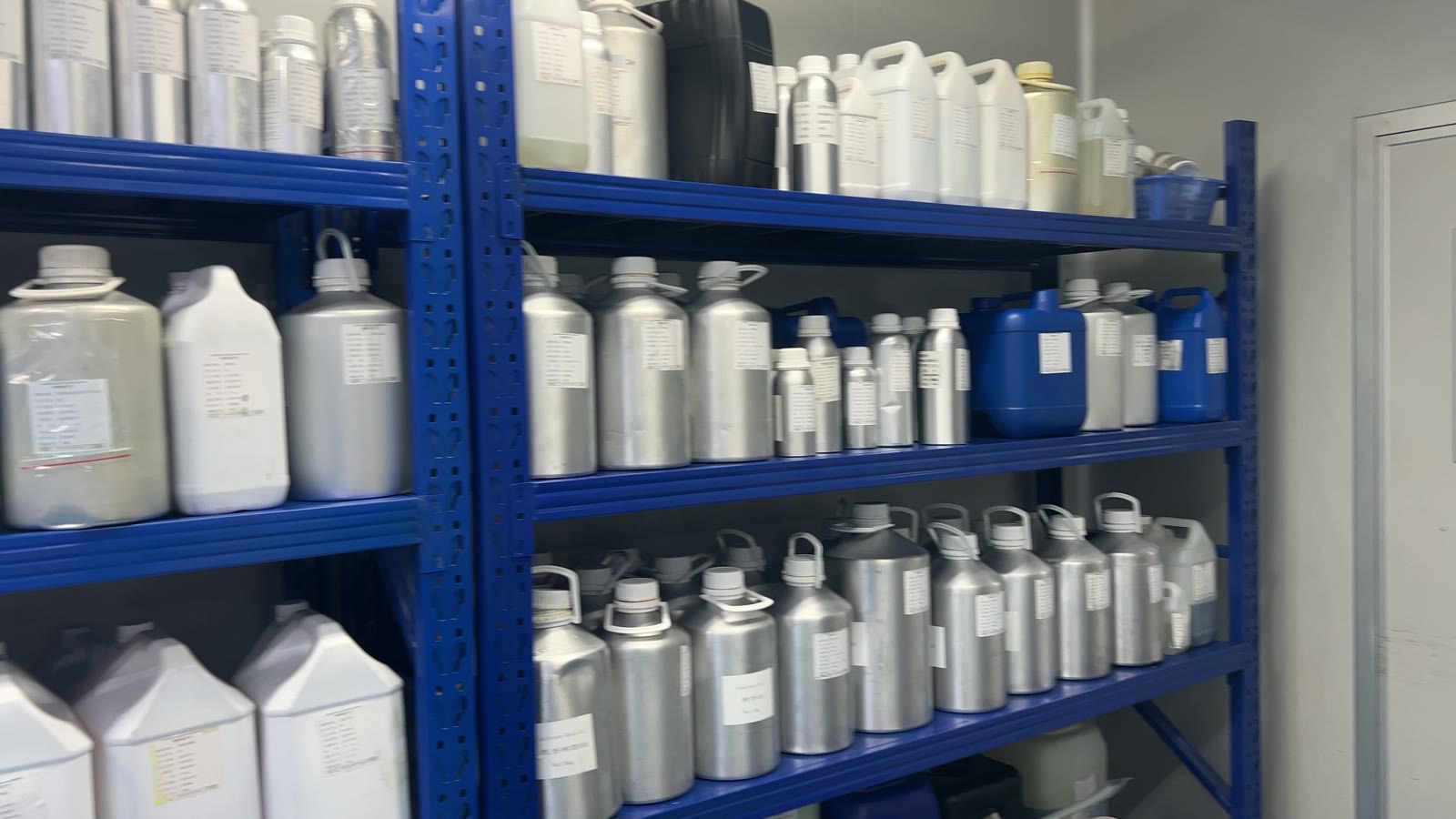 Shelves of aluminium and plastic containers holding essential oils and carrier oils
